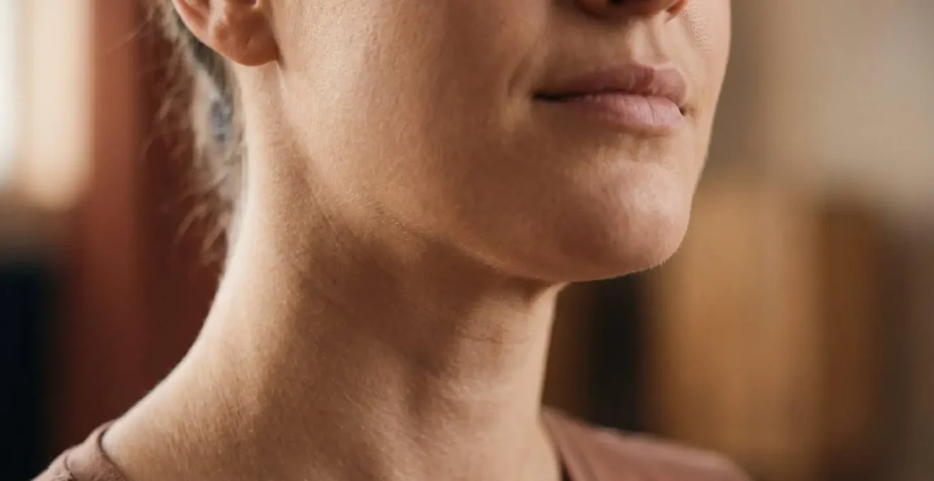 Close-up of a person's neck and throat area during ujjayi breathing practice with soft natural lighting